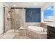 Luxurious bathroom featuring separate glass shower, soaking tub, and elegant finishes at 19316 W 84Th Pl, Arvada, CO 80007