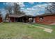 Spacious backyard featuring a covered patio, green lawn, and detached garage at 7747 Quivas St, Denver, CO 80221