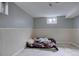Basement with painted walls and light tile flooring featuring a futon on the floor at 7747 Quivas St, Denver, CO 80221