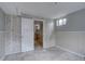 Unfinished basement with painted walls, light tile flooring, and an open doorway at 7747 Quivas St, Denver, CO 80221