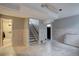 Spacious basement area with tile flooring, wood-paneled walls, and stairway access at 7747 Quivas St, Denver, CO 80221