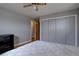 Neutral bedroom with hardwood flooring, ceiling fan, large closet with sliding doors and gray walls at 7747 Quivas St, Denver, CO 80221