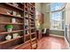 Home office featuring custom shelving, a rolling ladder, and bright windows with shutters at 3773 S Dayton Way, Aurora, CO 80014