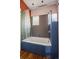 Colorful bathroom featuring a shower-tub combo with gray tiling and a blue-tiled tub at 756 Steele St, Denver, CO 80206