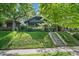 Home exterior on a lush green lot with mature trees and a concrete staircase leading to the entrance at 756 Steele St, Denver, CO 80206