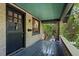 Welcoming covered front porch with gray decking, brick pillars, and an attractive front door at 756 Steele St, Denver, CO 80206