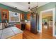 Modern kitchen featuring updated appliances, wood cabinetry, stainless steel accents, and an adjacent dining area at 756 Steele St, Denver, CO 80206