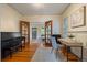 Comfortable home office featuring hardwood floors, a desk, piano, and views of the living areas at 756 Steele St, Denver, CO 80206