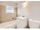 Updated bathroom featuring tiled shower over tub, vanity with storage, and modern lighting at 970 Lima St, Aurora, CO 80010