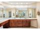 Bathroom with dual sinks, wood cabinets, and tile flooring at 395 Winterthur Way, Highlands Ranch, CO 80129