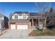 Two-story home with a three-car garage and a brick facade at 395 Winterthur Way, Highlands Ranch, CO 80129