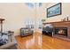 Cozy living room with hardwood floors, fireplace, large windows, and high ceilings at 395 Winterthur Way, Highlands Ranch, CO 80129