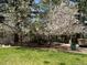 Picturesque yard featuring blossoming trees, green lawn, and a peaceful seating area at 720 N Bluff Dr, Franktown, CO 80116