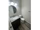 Bathroom with updated granite sink, modern faucet, round mirror and wood look floor at 9762 Appletree Pl, Thornton, CO 80260