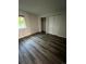Bedroom with wood-look flooring and closet with shutter doors at 9762 Appletree Pl, Thornton, CO 80260