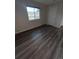 Bedroom featuring wood-look floors, a window, and a white door at 9762 Appletree Pl, Thornton, CO 80260