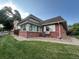 Charming brick home featuring a sunroom, manicured lawn, and mature trees at 9762 Appletree Pl, Thornton, CO 80260