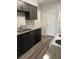 Kitchen featuring updated appliances, countertops, dark cabinets, and laminate flooring at 9762 Appletree Pl, Thornton, CO 80260