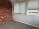 Room with carpeted floors, brick wall accent, and natural light from multiple windows at 9762 Appletree Pl, Thornton, CO 80260