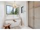 Bright bathroom with soaking tub, elegant lighting, neutral color palette and storage cabinet at 1118 Northwood Ln, Castle Rock, CO 80108