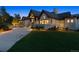 Front exterior featuring stone and wood accents, a dark roof, manicured lawn, and circular driveway at 1118 Northwood Ln, Castle Rock, CO 80108