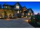 Exterior of home at night featuring manicured landscaping, a stone facade, and a circular driveway at 1118 Northwood Ln, Castle Rock, CO 80108