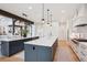 Open-concept kitchen featuring dual islands, pendant lighting, hardwood floors, and barstool seating at 1118 Northwood Ln, Castle Rock, CO 80108