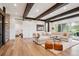 Open-concept living room with wood beams, stone accent wall, and an extra large sectional sofa at 1118 Northwood Ln, Castle Rock, CO 80108