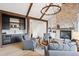 Inviting living room featuring wood beams, a custom wet bar, and stone fireplace with built-in shelving at 1118 Northwood Ln, Castle Rock, CO 80108