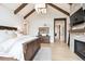 Spacious bedroom featuring exposed beam ceiling, hardwood floors, fireplace and neutral color palette at 1118 Northwood Ln, Castle Rock, CO 80108