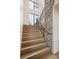 Staircase with hardwood steps, dark metal railing, and stone accent wall under lots of natural light at 1118 Northwood Ln, Castle Rock, CO 80108