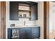 Convenient wet bar equipped with beverage cooler, sink, and cabinetry with shelving at 1118 Northwood Ln, Castle Rock, CO 80108