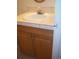 Bathroom sink with a tile countertop and wood cabinets below create a functional space at 10742 E Exposition Ave # 124, Aurora, CO 80012