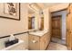 Neutral bathroom with a tiled floor, granite vanity top, and wooden doors at 6953 W Roxbury Pl, Littleton, CO 80128