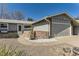 Well maintained front exterior with charming landscaping, featuring stone and brick accents at 6953 W Roxbury Pl, Littleton, CO 80128