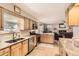 Bright kitchen with stainless appliances, granite counters, and view into the living room at 6953 W Roxbury Pl, Littleton, CO 80128