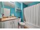 Bright bathroom featuring turquoise walls, a white vanity with a drop-in sink, and a shower-tub combo at 5786 Raleigh Cir, Castle Rock, CO 80104