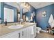 Double sink bathroom with dark blue walls, modern fixtures, and plenty of natural light at 5786 Raleigh Cir, Castle Rock, CO 80104