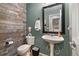 Stylish half-bathroom featuring wood paneling, pedestal sink, and modern fixtures at 5786 Raleigh Cir, Castle Rock, CO 80104