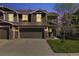Charming townhome featuring a two-car garage, stone accents, and a well-maintained lawn at 5786 Raleigh Cir, Castle Rock, CO 80104