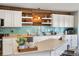 Bright kitchen with white cabinetry, blue backsplash, floating shelves, and a wood accent wall at 5786 Raleigh Cir, Castle Rock, CO 80104