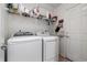 Functional laundry room with modern washer and dryer, storage shelf, and easy access at 5786 Raleigh Cir, Castle Rock, CO 80104