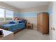 A cozy bedroom with natural light, a striped accent wall, and ample closet space at 9745 Quay Loop, Westminster, CO 80021
