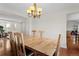 Dining area with hardwood floors, light wood table set for six, and chandelier at 9745 Quay Loop, Westminster, CO 80021