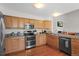 Kitchen features wooden cabinets, stainless steel appliances and views of the living room at 9745 Quay Loop, Westminster, CO 80021