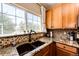 Kitchen with granite countertops, double sink, and mosaic backsplash at 23376 E 5Th Pl # 101, Aurora, CO 80018