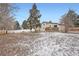 Large fenced backyard with some snow cover, mature trees and grass, and an outdoor deck at 6374 Upham St, Arvada, CO 80003