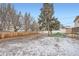 Large fenced backyard with mature trees, a grassy area with a picnic table, and some snow-covered ground at 6374 Upham St, Arvada, CO 80003