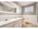 Bathroom featuring dual sinks, a large mirror, and a shower-tub combo in a well-lit space at 6374 Upham St, Arvada, CO 80003