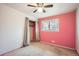 Bedroom with pink accent wall, carpet flooring, and an open closet at 6374 Upham St, Arvada, CO 80003